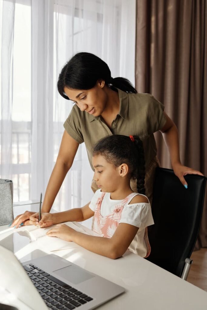 A mother helps her daughter with homework, highlighting education and family bonding indoors.